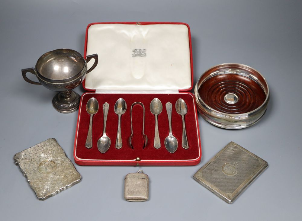 Mixed silver including cased set of six teaspoons, card case, aide memoir, vesta, Irish trophy cup and modern wine coaster.